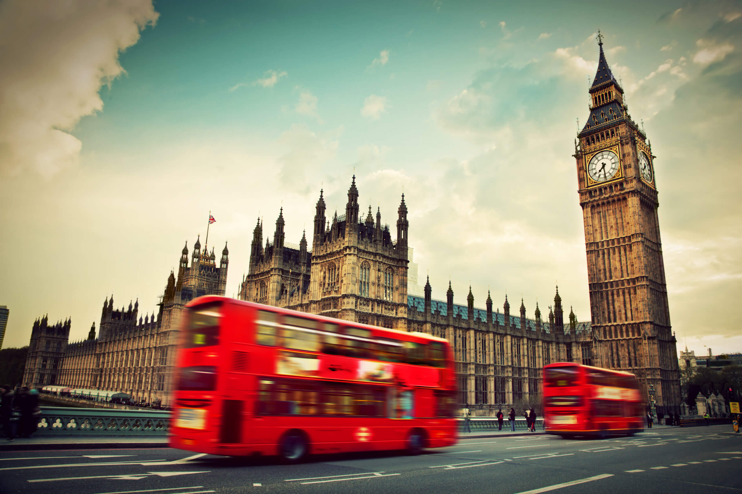 Røde dobbeltdækker busser i bevægelse foran Westminister og Big Ben